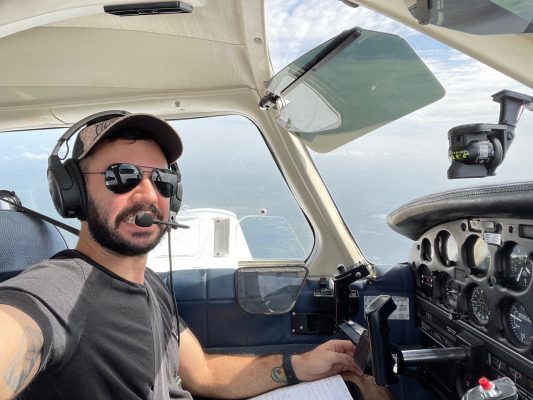 Alain in the cockpit of a plane that's in the sky.